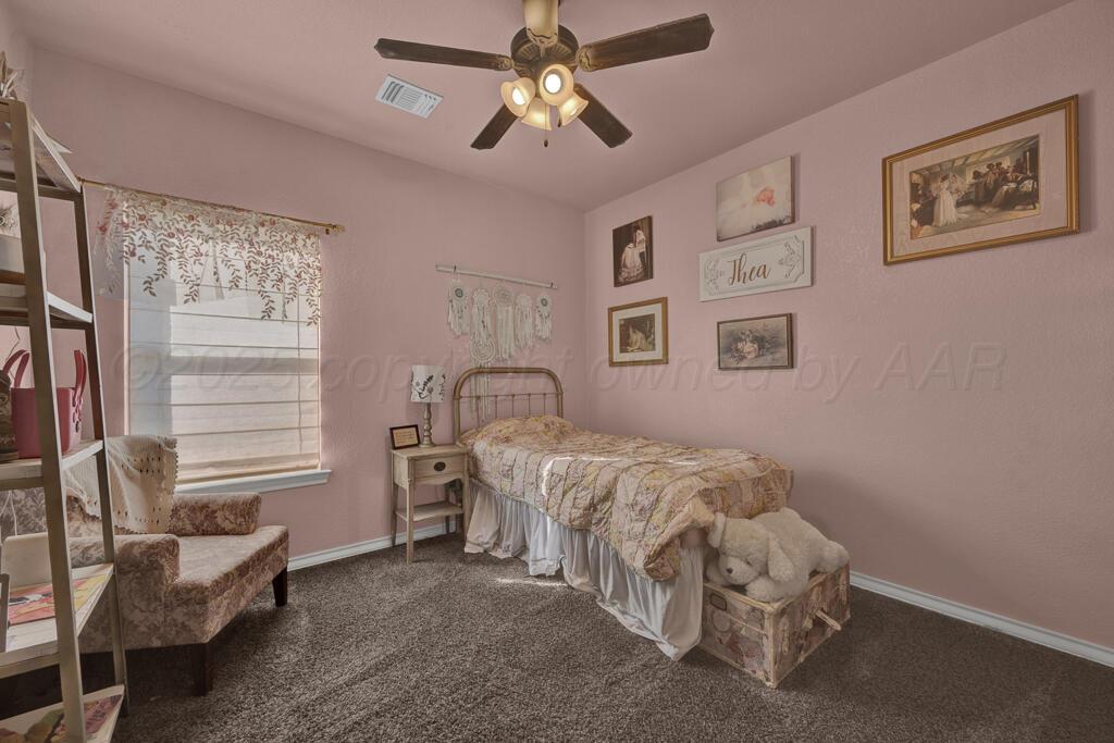 17801 Stone Creek Road Amarillo, TX 79124 - Photo 17 of 31 a bedroom with a bed and a chandelier