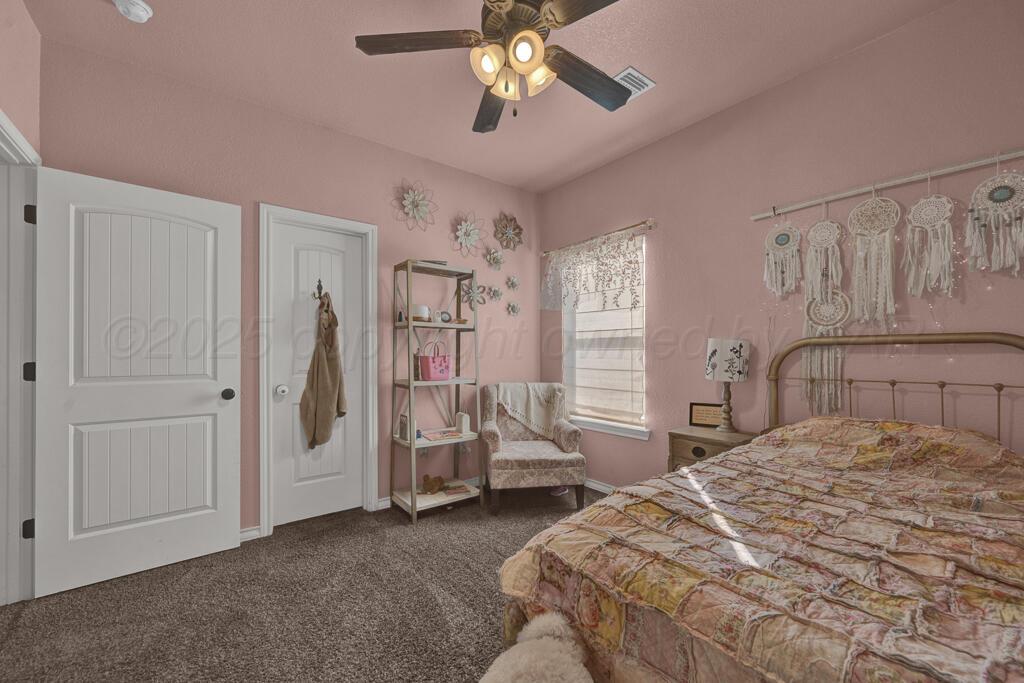 17801 Stone Creek Road Amarillo, TX 79124 - Photo 18 of 31 a bedroom with a bed and a chandelier