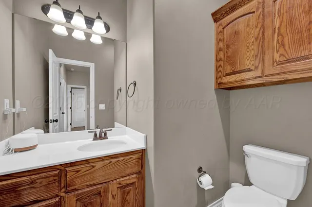 a bathroom with a toilet a sink and mirror