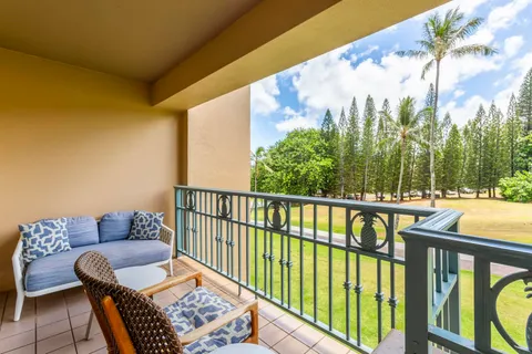 a balcony with wooden floor and outdoor seating