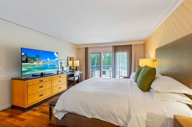 a bedroom with a bed and large windows