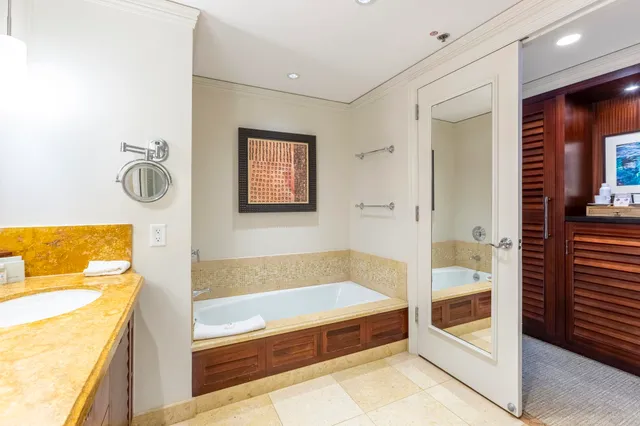 a bathroom with a tub a sink and mirror