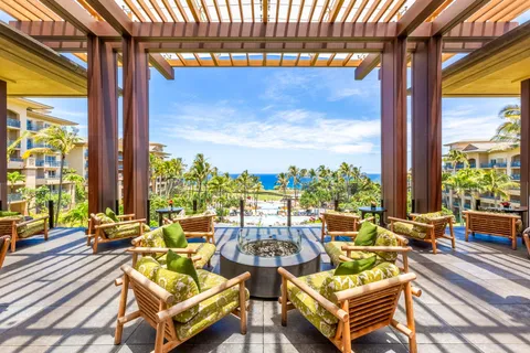 a view of a swimming pool with a table and chairs potted plants