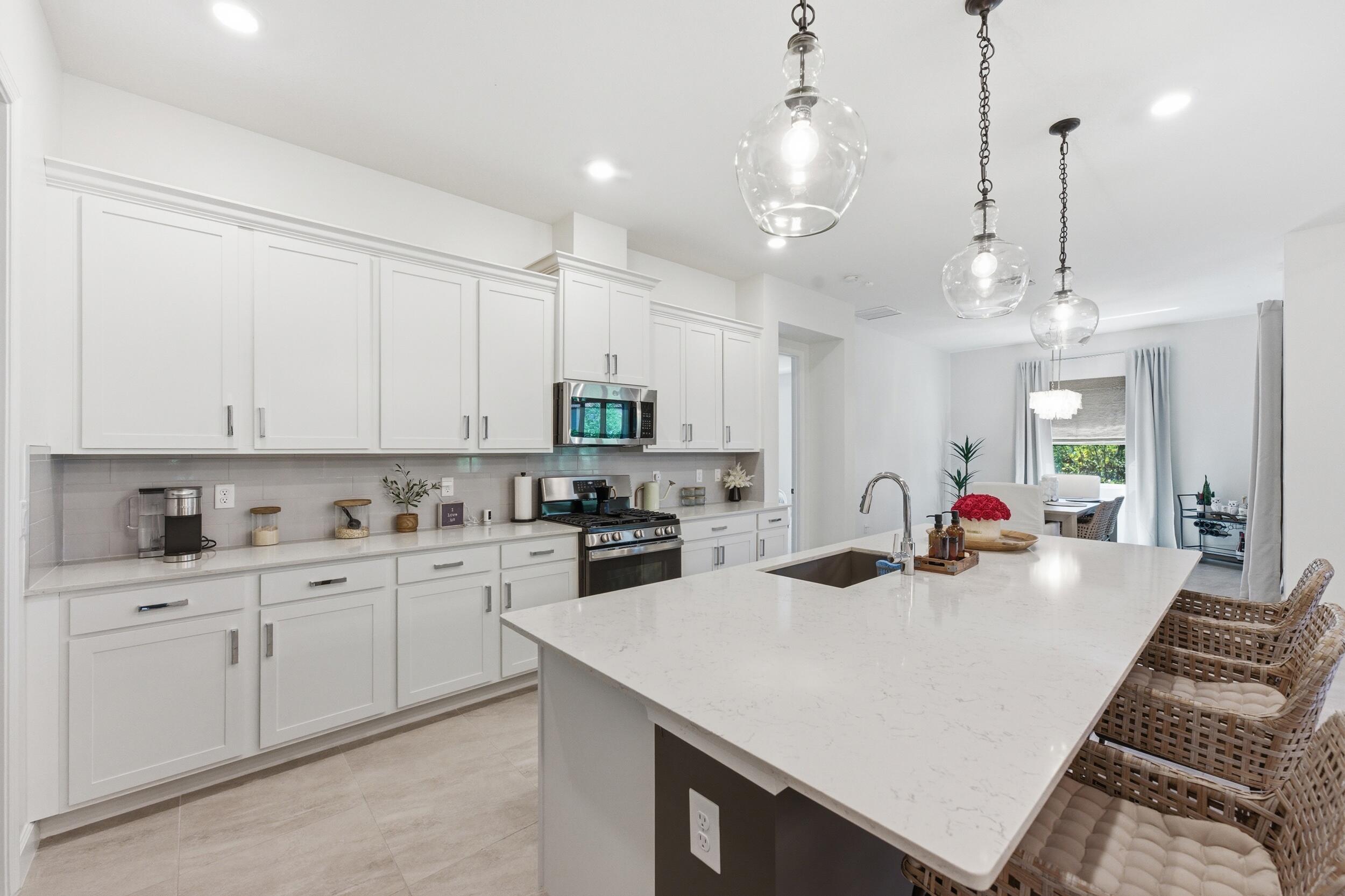 19230 Rolling Acres Road Loxahatchee, FL 33470 - Photo 32 of 58 a kitchen with sink a stove and cabinets