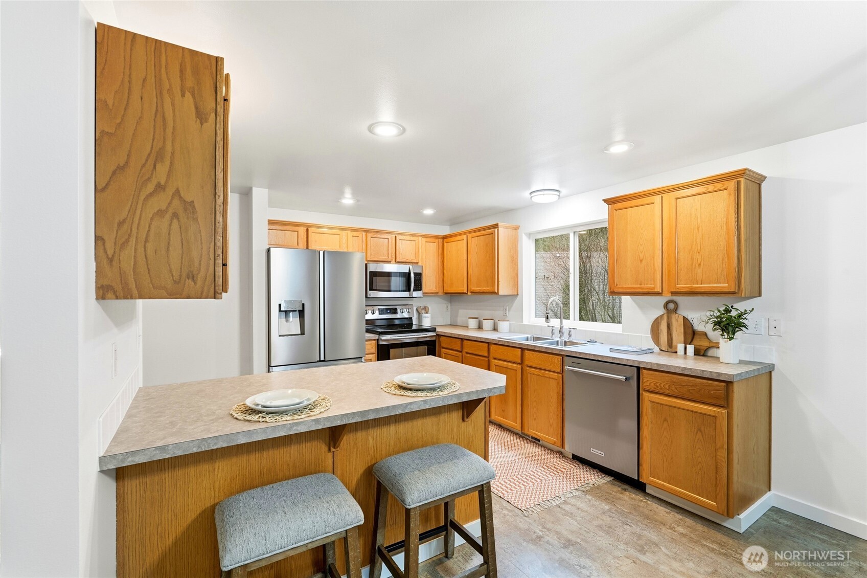 18219 58th St Court East Lake Tapps, WA 98391 - Photo 14 of 40 a kitchen with a table chairs sink and cabinets
