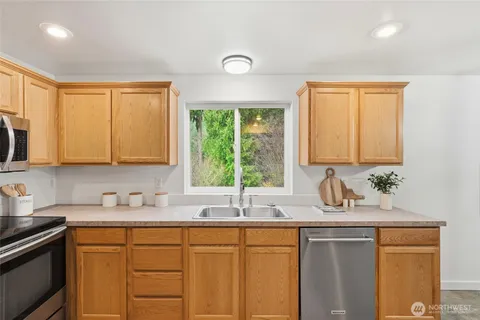 a kitchen with sink a window and cabinets