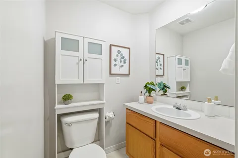 a bathroom with a toilet sink and mirror