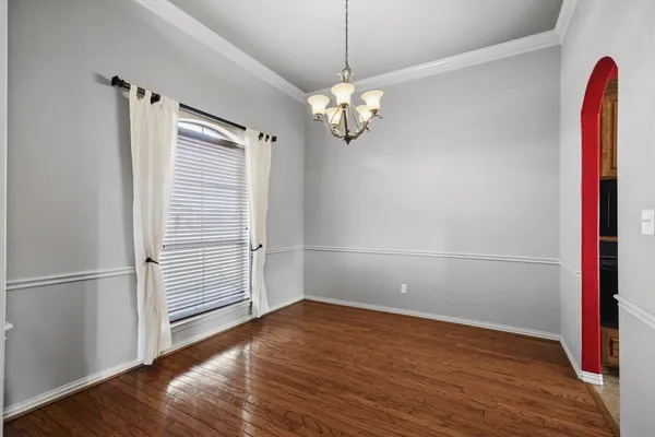 a view of a hallway with wooden floor and a livingroom