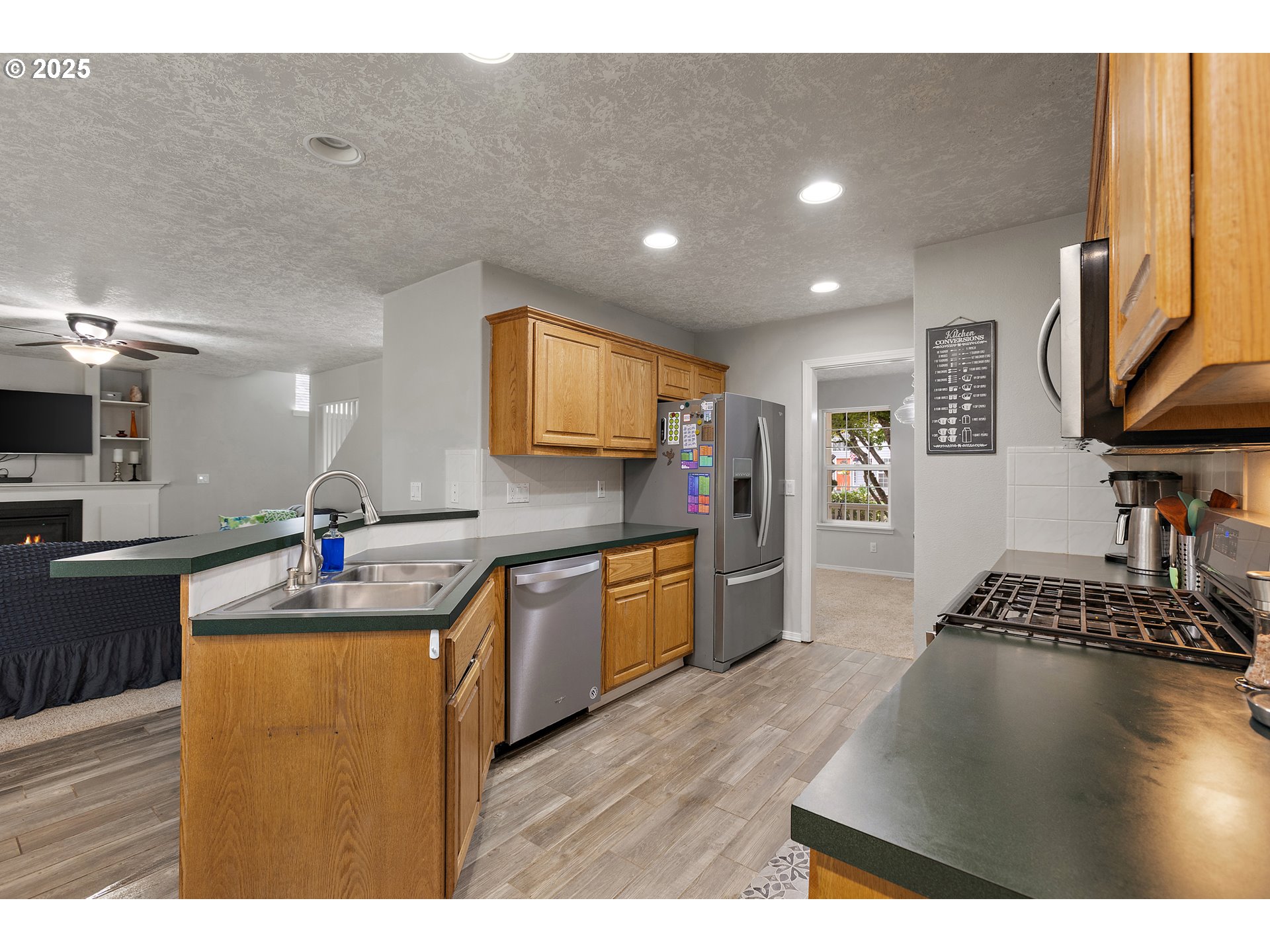 7771 St Charles Street Northeast Keizer, OR 97303 - Photo 11 of 42 a kitchen view with stainless steel appliances granite countertop a sink dishwasher a stove and a refrigerator with wooden floor