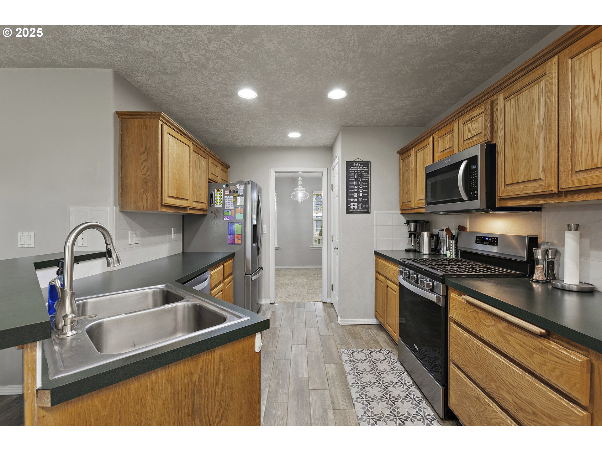 7771 St Charles Street Northeast Keizer, OR 97303 - Photo 12 of 42 a kitchen with stainless steel appliances granite countertop a sink stove and refrigerator