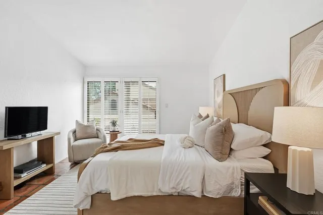 a bedroom with a bed and a flat screen tv