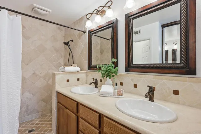 a en suite bathroom with a granite countertop sink and a mirror