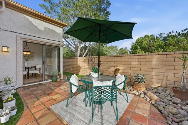 a view of a patio with a table and chairs under an umbrella