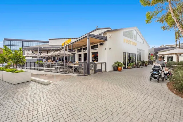a view of a cafe with tables and chairs under an umbrella