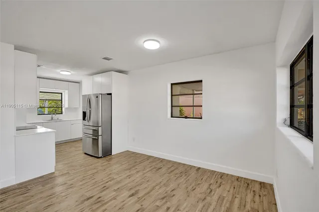 a view of empty room with wooden floor and window