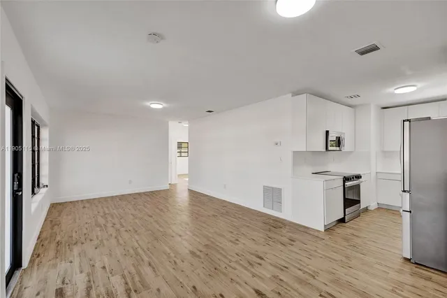 a kitchen with stainless steel appliances a refrigerator and a stove top oven