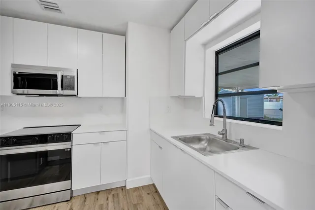 a kitchen with a sink stove and microwave