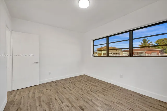 a view of a room with wooden floor and window