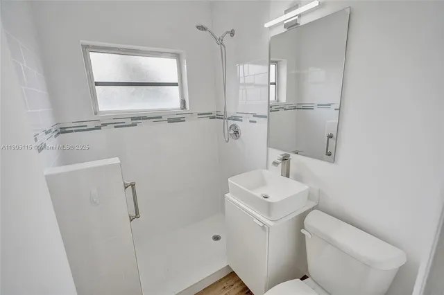 a bathroom with a toilet sink and mirror