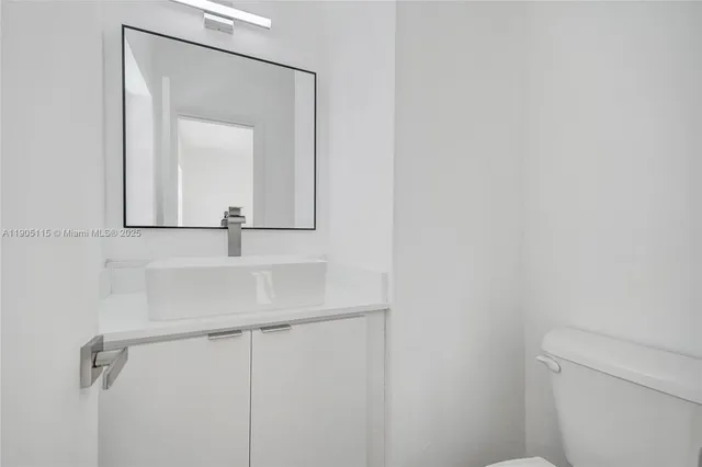 a bathroom with a sink and mirror with toilet