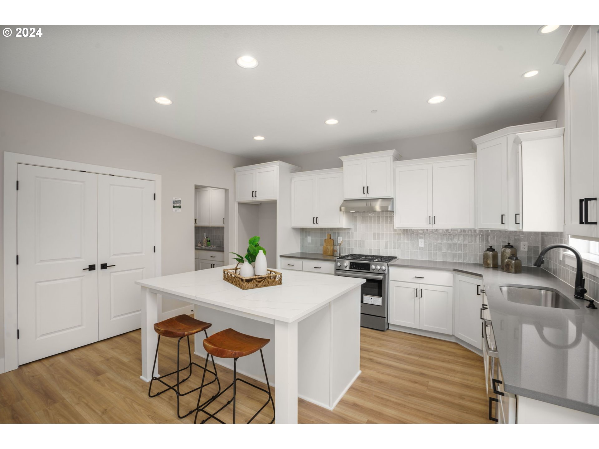 7209 Northeast Ridge Drive, Unit LOT 1 Hillsboro, OR 97124 - Photo 2 of 25 a kitchen with stainless steel appliances kitchen island granite countertop a stove a sink a refrigerator and white cabinets with wooden floor