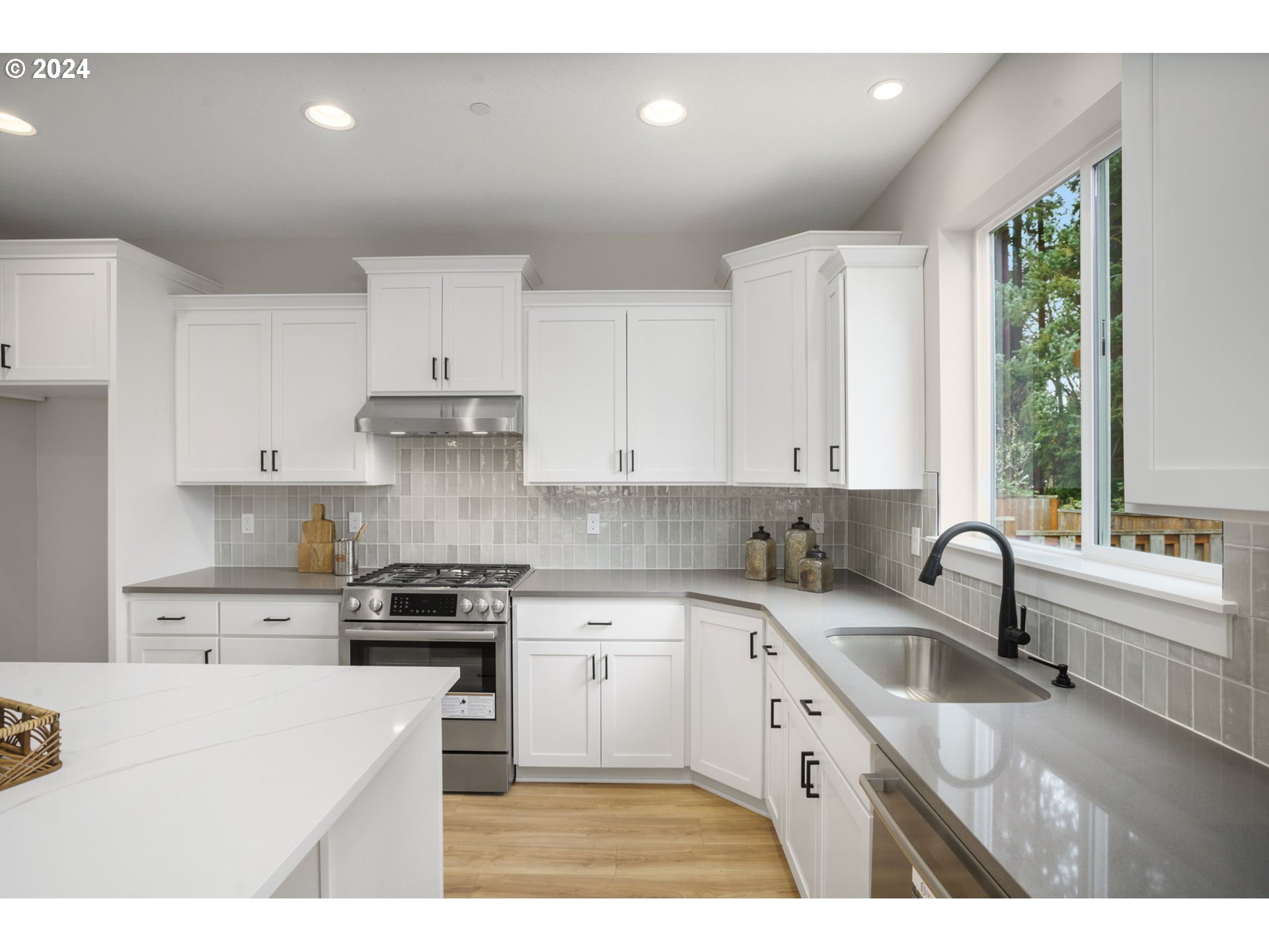 7209 Northeast Ridge Drive, Unit LOT 1 Hillsboro, OR 97124 - Photo 3 of 25 a kitchen with kitchen island granite countertop a sink a counter space appliances and cabinets