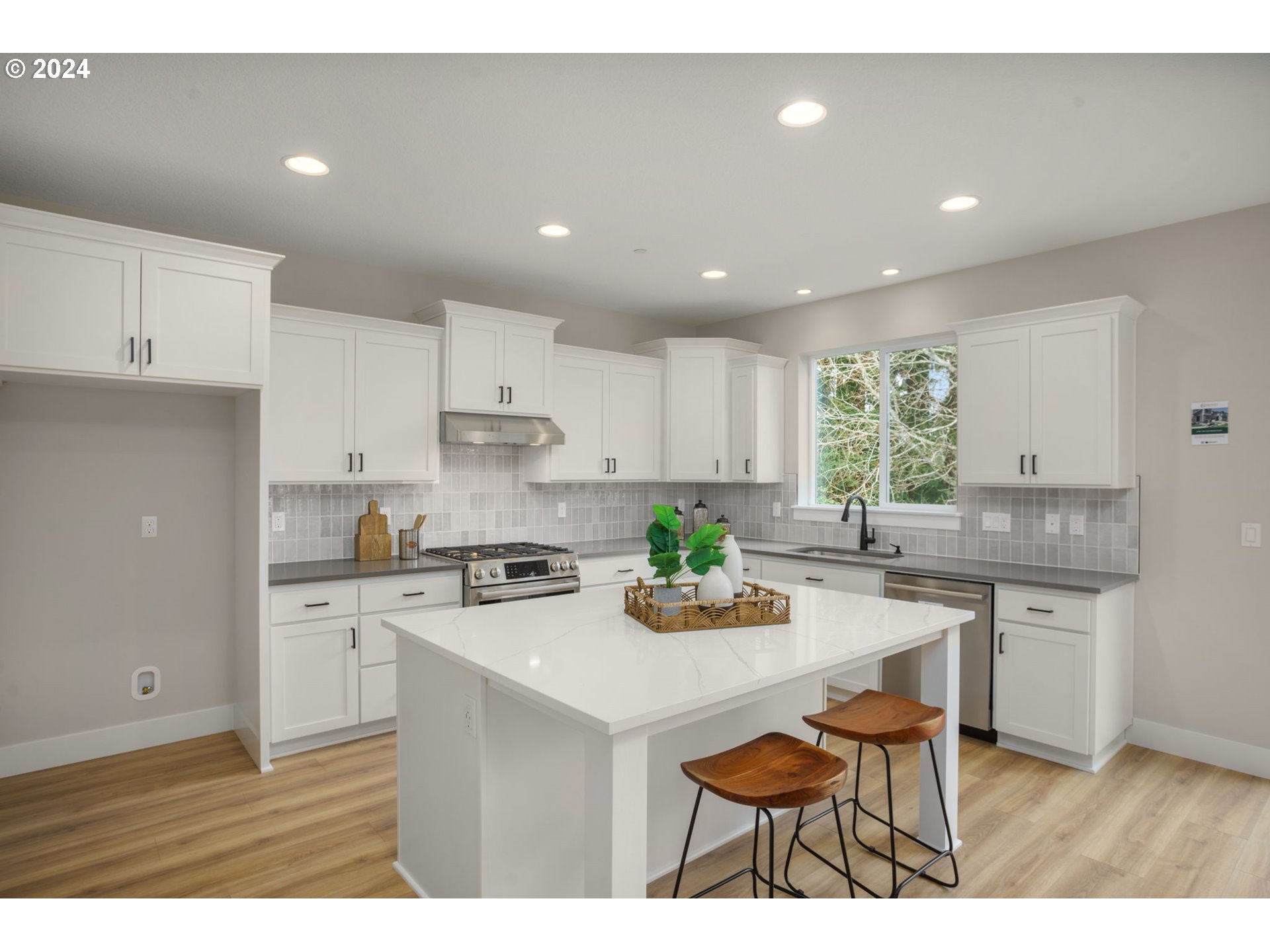 7209 Northeast Ridge Drive, Unit LOT 1 Hillsboro, OR 97124 - Photo 7 of 25 a kitchen with a sink a stove a refrigerator and white cabinets with wooden floor