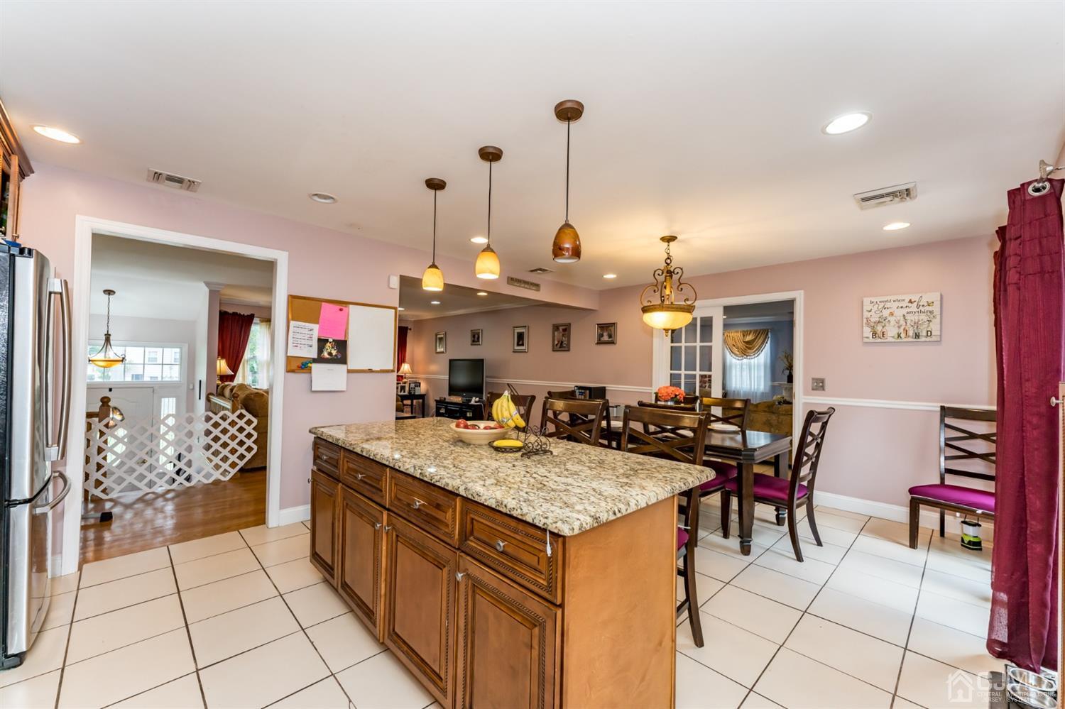 199 Stafford Road Colonia, NJ 07067 - Photo 8 of 44 a large kitchen with kitchen island a stove a sink a dining table and chairs