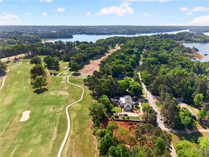 an aerial view of residential houses with outdoor space and trees