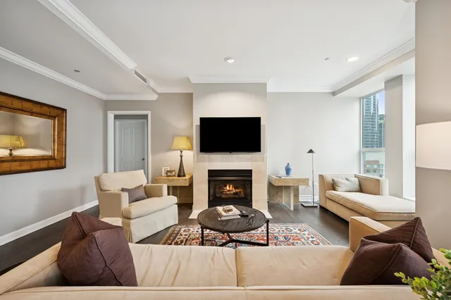 a living room with furniture a flat screen tv and a fireplace