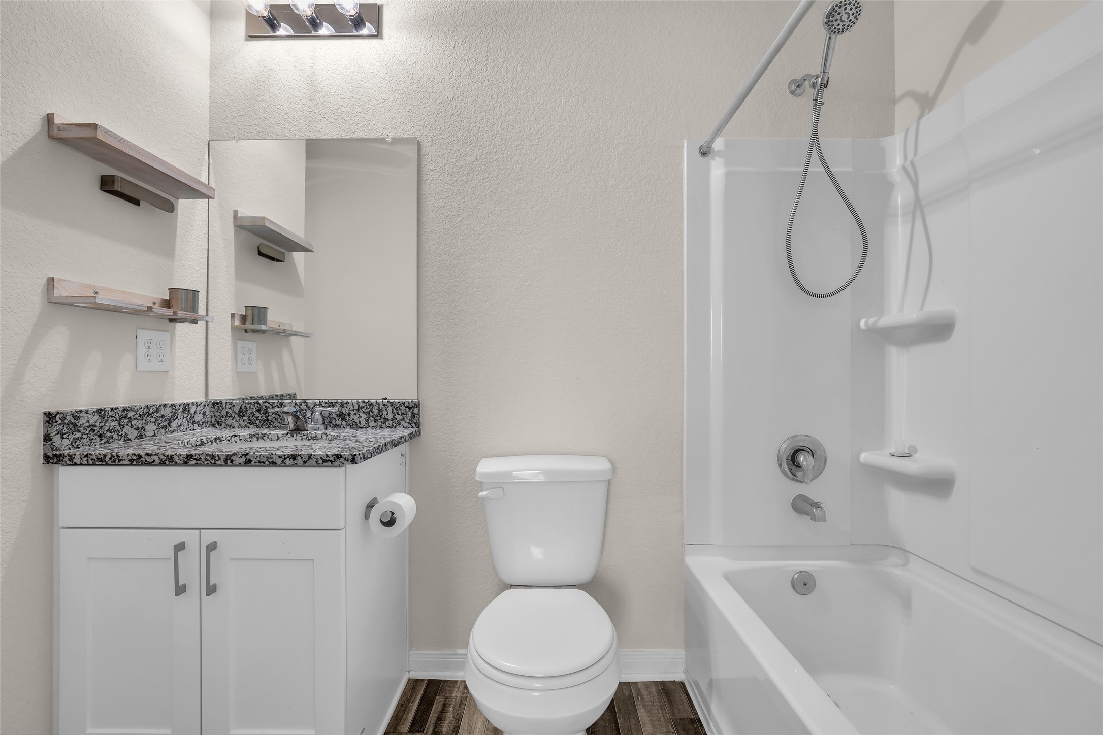 2511 17th Street Hempstead, TX 77445 - Photo 18 of 23 a bathroom with a granite countertop toilet a sink and a bathtub