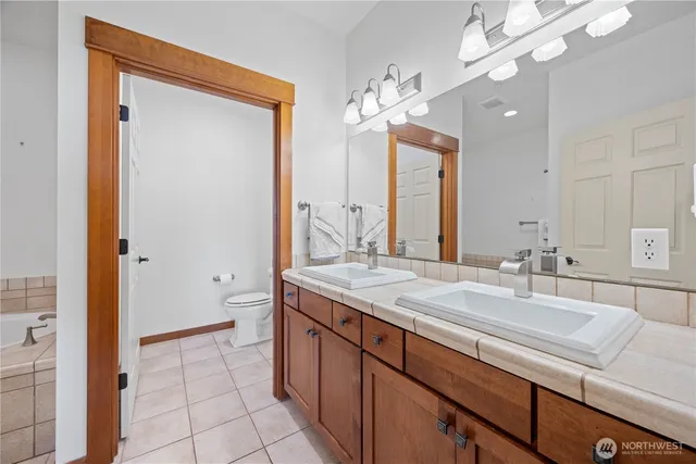 a spacious bathroom with a granite countertop sink a mirror and a shower