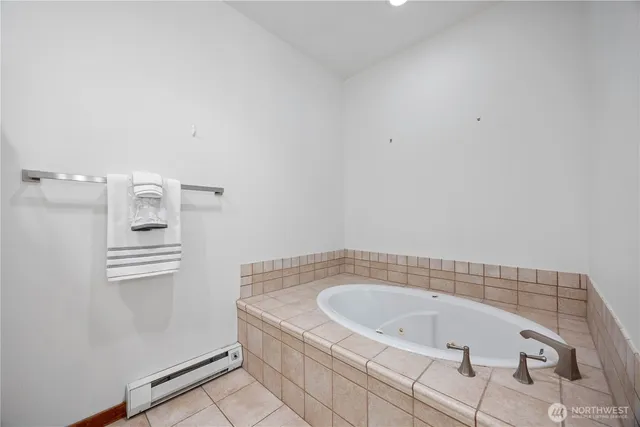a bathroom with a tub sink and mirror