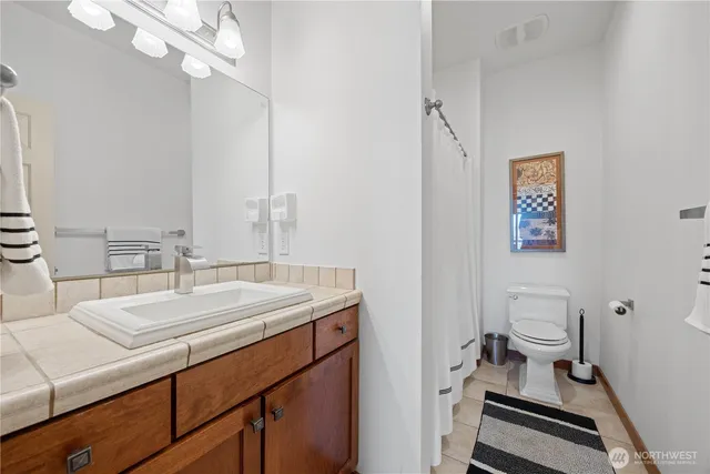 a bathroom with a sink a toilet and a mirror