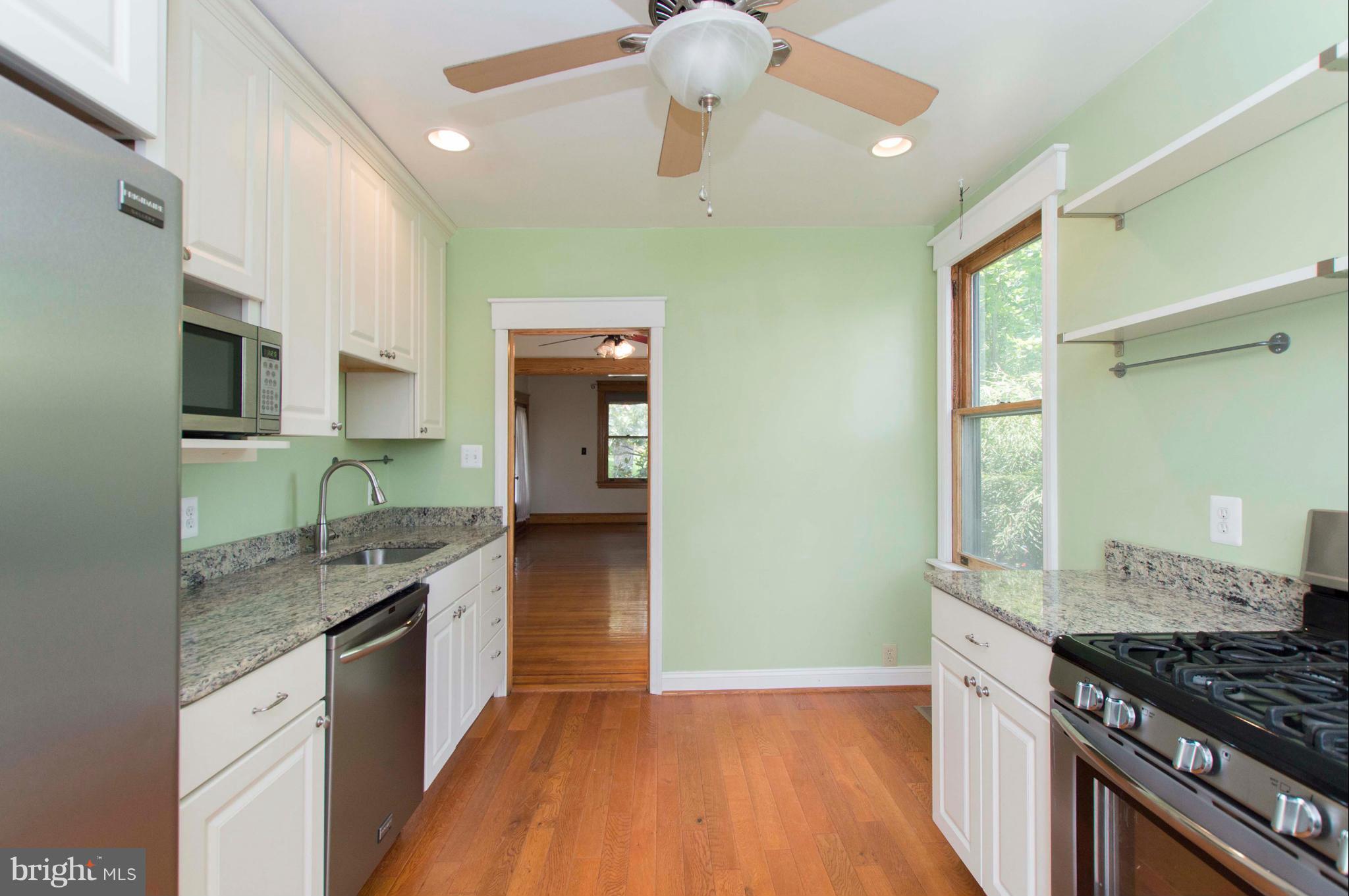 1007 Overbrook Road Baltimore, MD 21239 - Photo 15 of 30 a kitchen with granite countertop a stove a sink and a refrigerator
