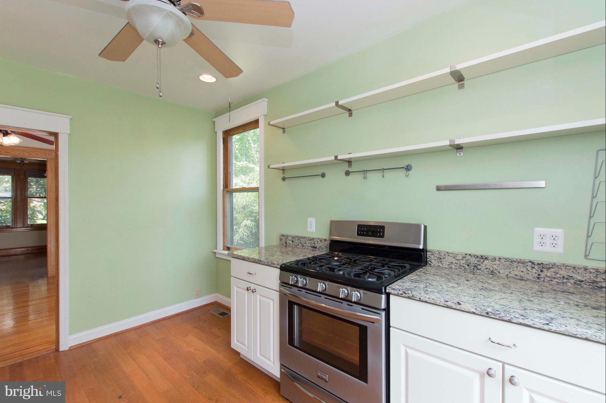 1007 Overbrook Road Baltimore, MD 21239 - Photo 16 of 30 a kitchen with a stove and a wooden floor