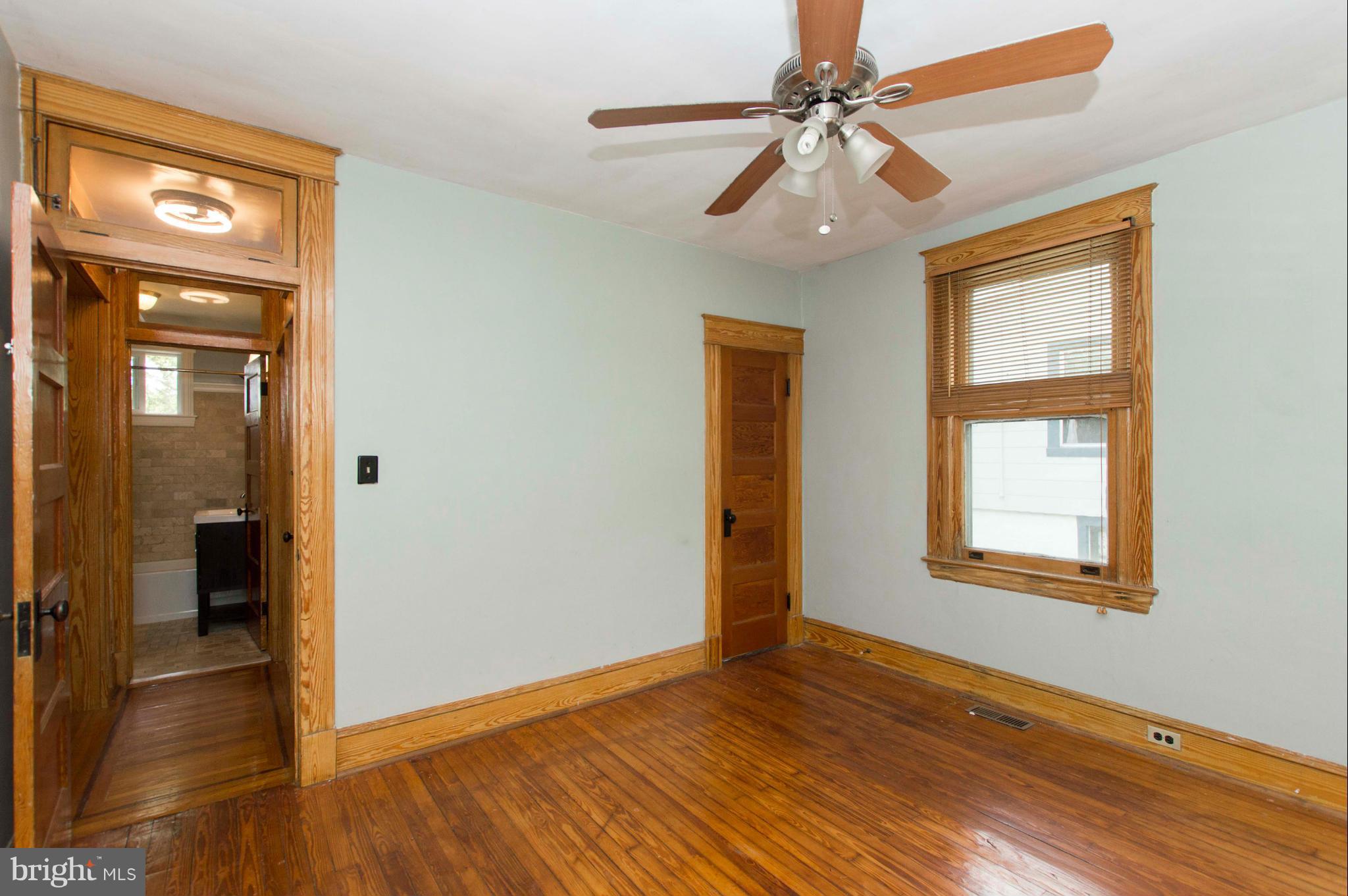 1007 Overbrook Road Baltimore, MD 21239 - Photo 18 of 30 a view of an empty room with window and wooden floor