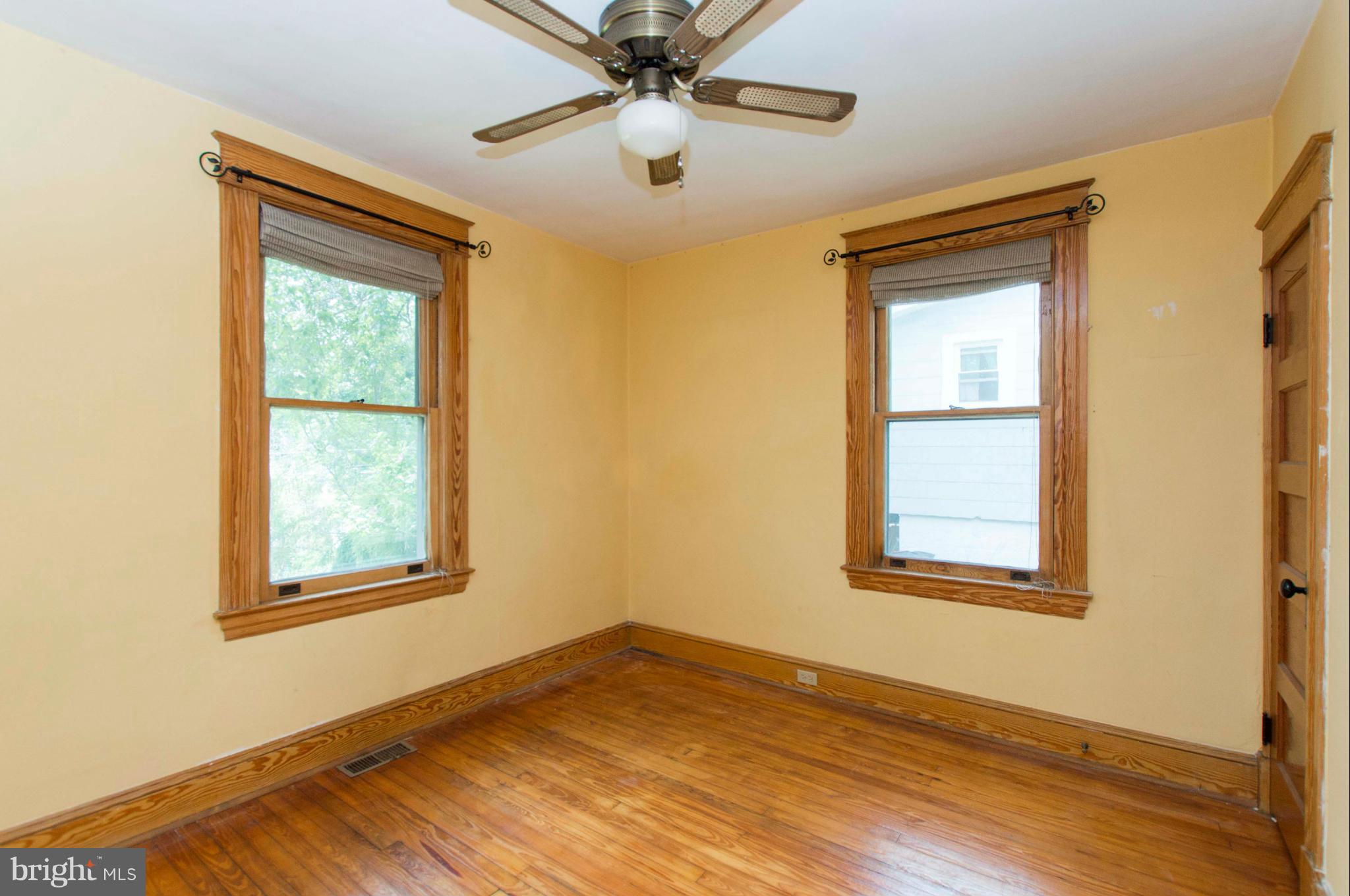 1007 Overbrook Road Baltimore, MD 21239 - Photo 22 of 30 a view of an empty room with wooden floor and a window