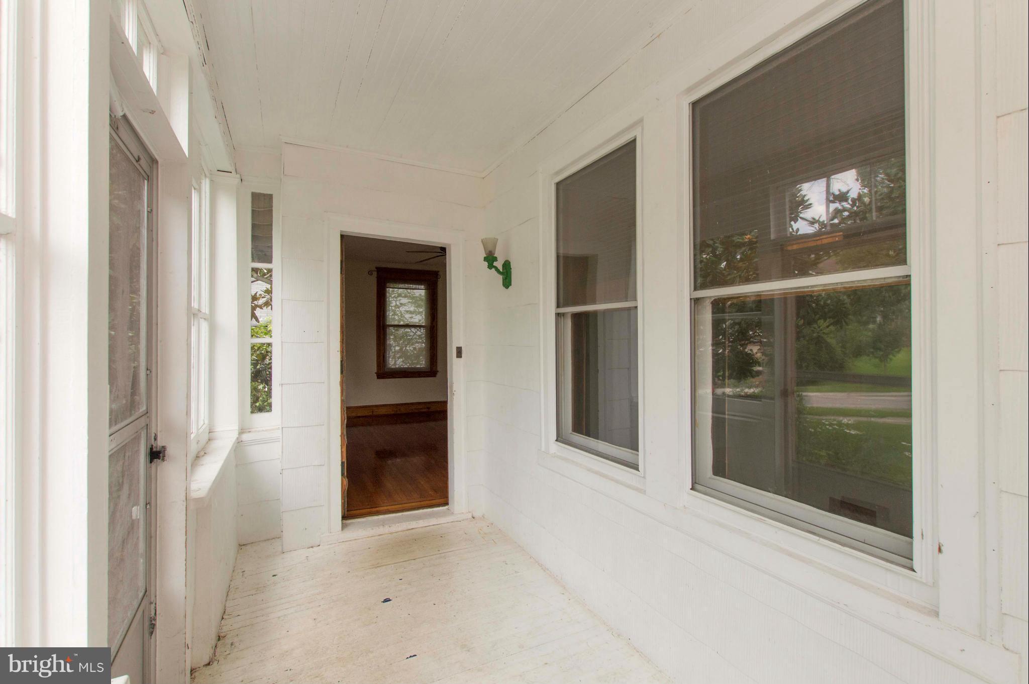 1007 Overbrook Road Baltimore, MD 21239 - Photo 4 of 30 a view of a hallway with wooden floor and a living room