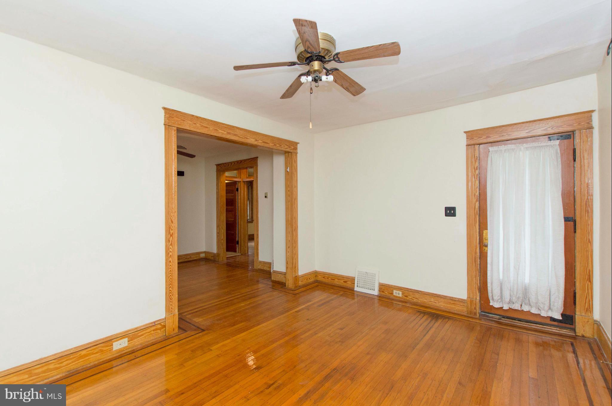 1007 Overbrook Road Baltimore, MD 21239 - Photo 6 of 30 a view of a room with wooden floor and a ceiling fan