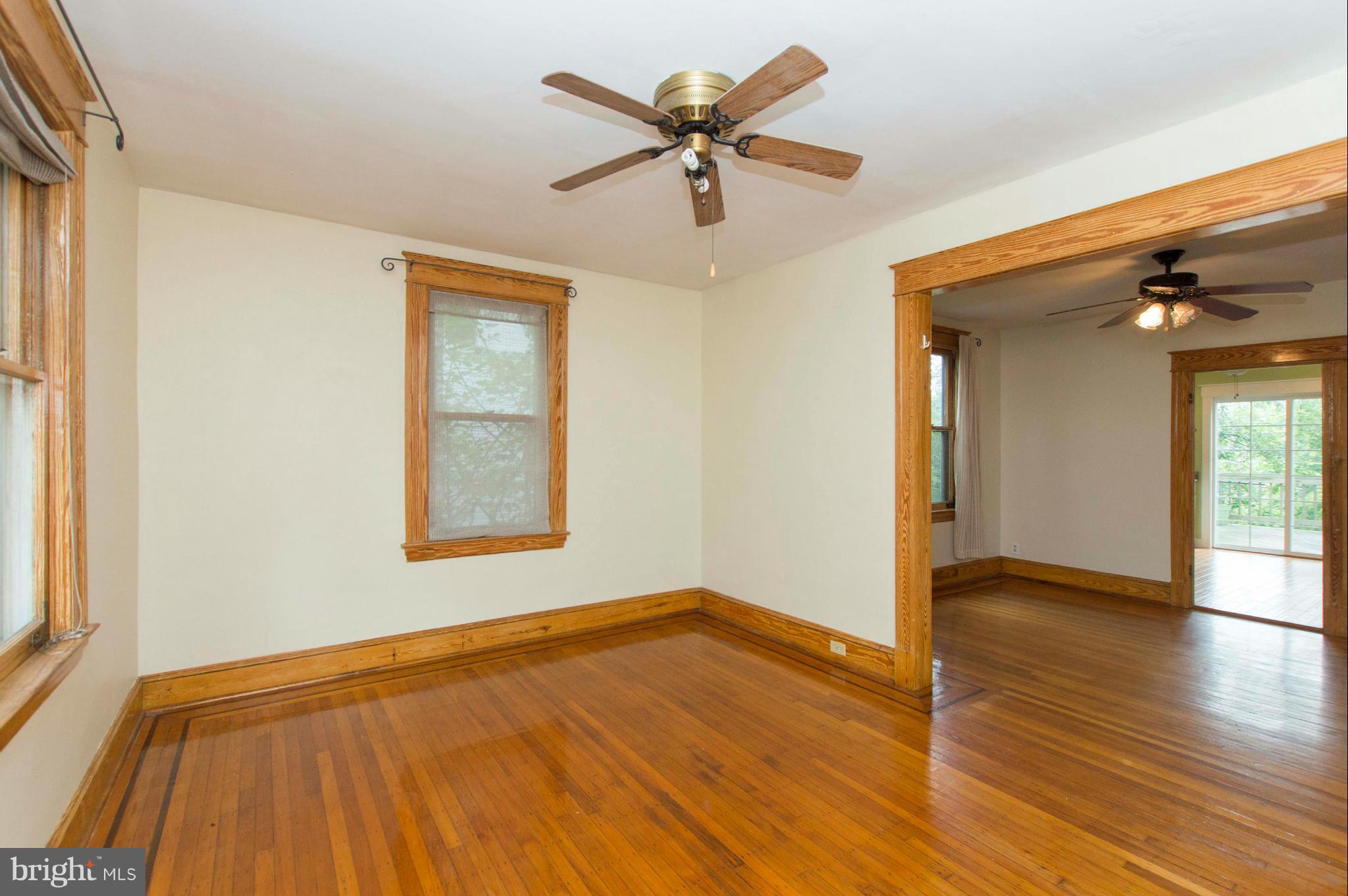 1007 Overbrook Road Baltimore, MD 21239 - Photo 7 of 30 an empty room with wooden floor and windows