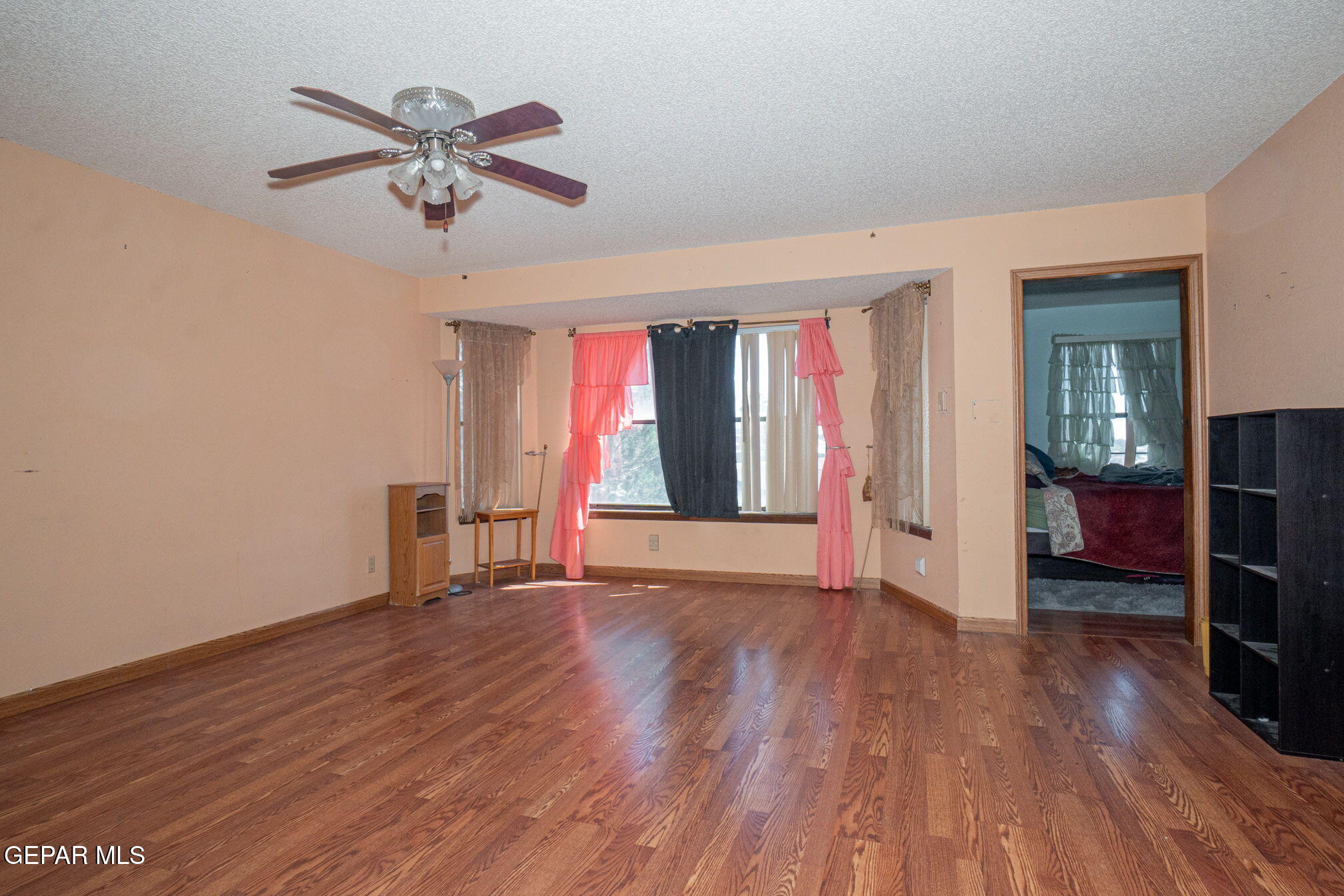 4643 R L Shoemaker Drive El Paso, TX 79924 - Photo 9 of 24 a view of an empty room with a window and wooden floor