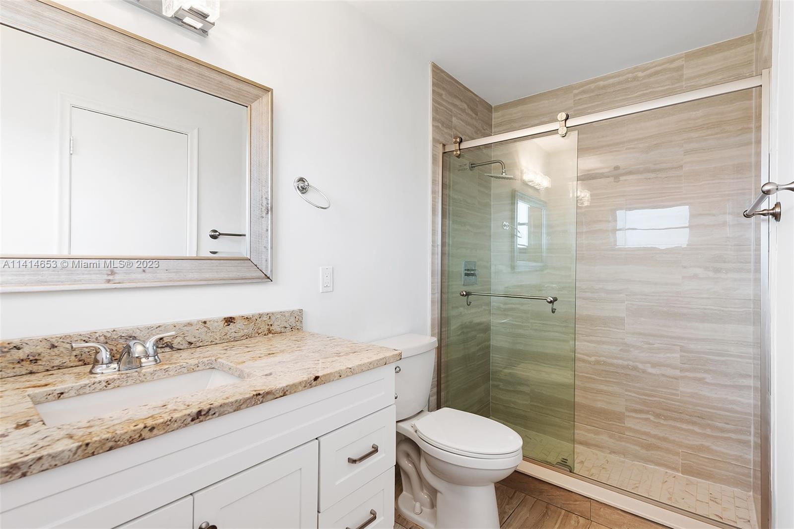 6240 Dusenburg Road Delray Beach, FL 33484 - Photo 17 of 25 a bathroom with a granite countertop sink toilet a mirror and shower