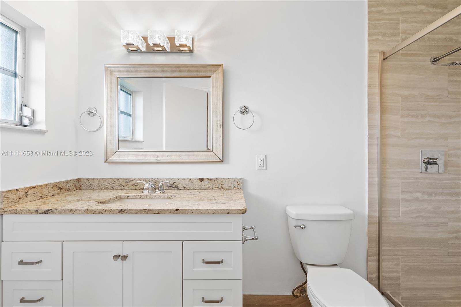 6240 Dusenburg Road Delray Beach, FL 33484 - Photo 18 of 25 a bathroom with a granite countertop toilet sink and mirror