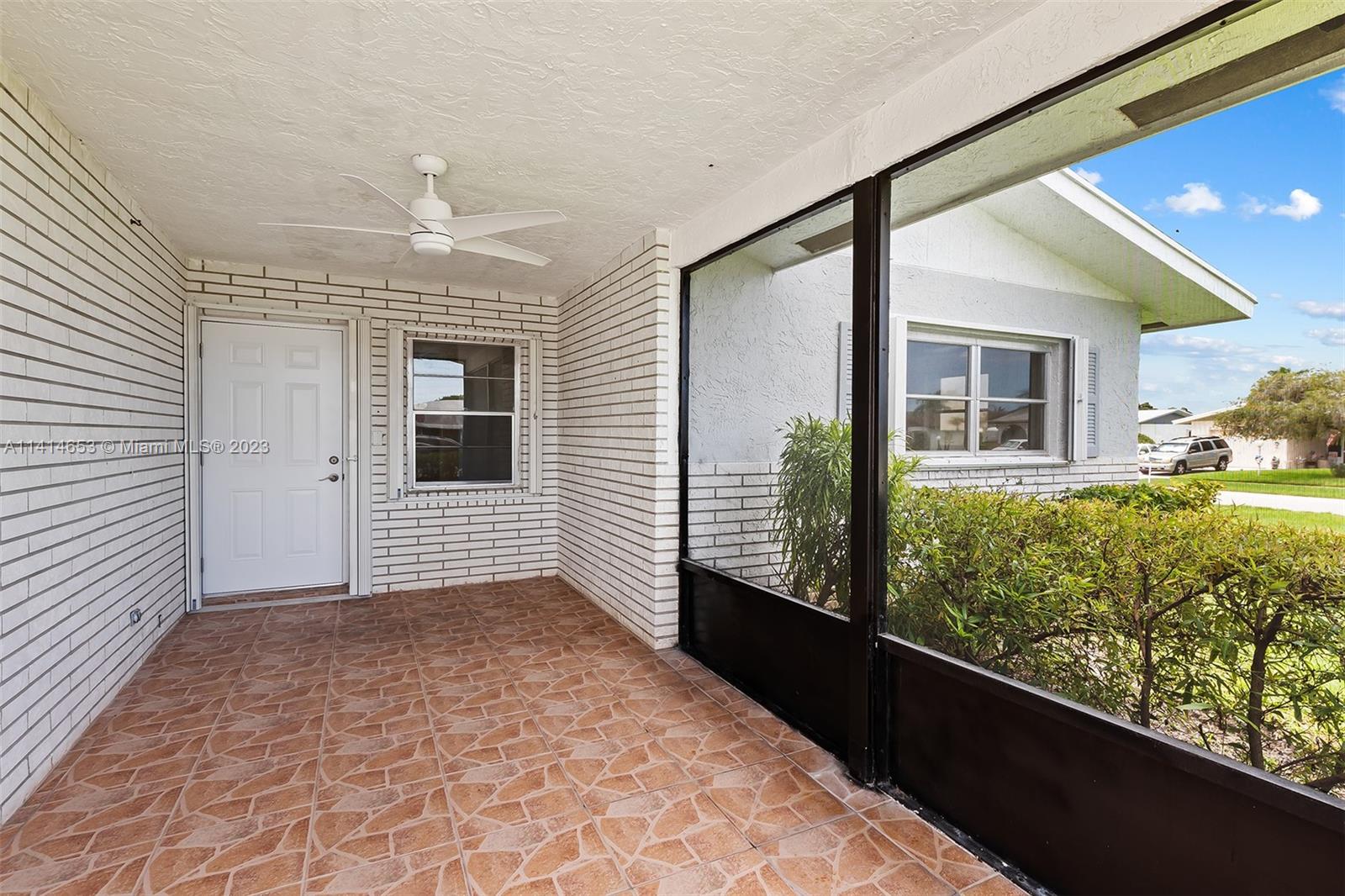6240 Dusenburg Road Delray Beach, FL 33484 - Photo 4 of 25 a view of a porch with wooden floor and a yard