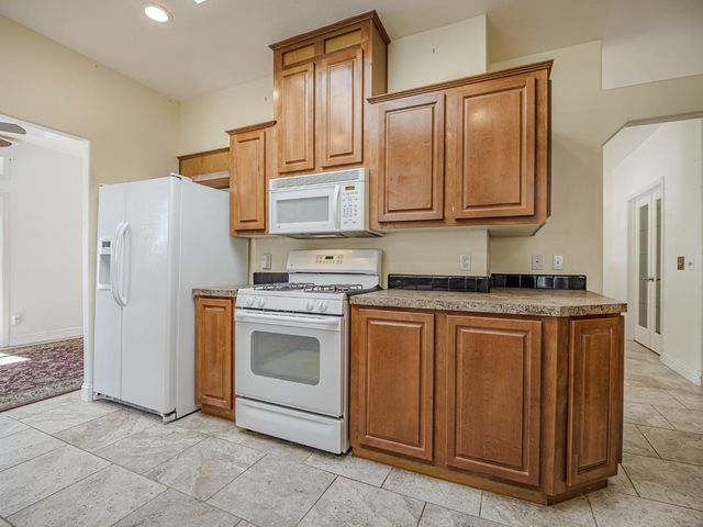 a kitchen with stainless steel appliances granite countertop a stove sink and cabinets