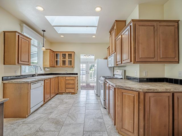 a kitchen with stainless steel appliances granite countertop a refrigerator stove and sink