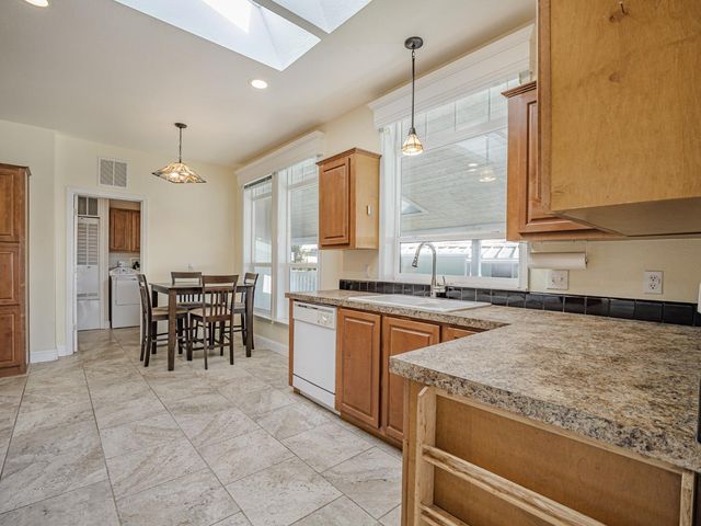 a living room with a table chairs and a kitchen view