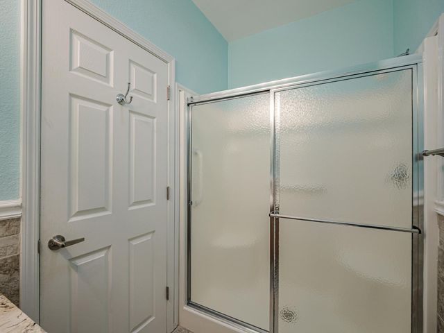 an empty room with chandelier fan and closet