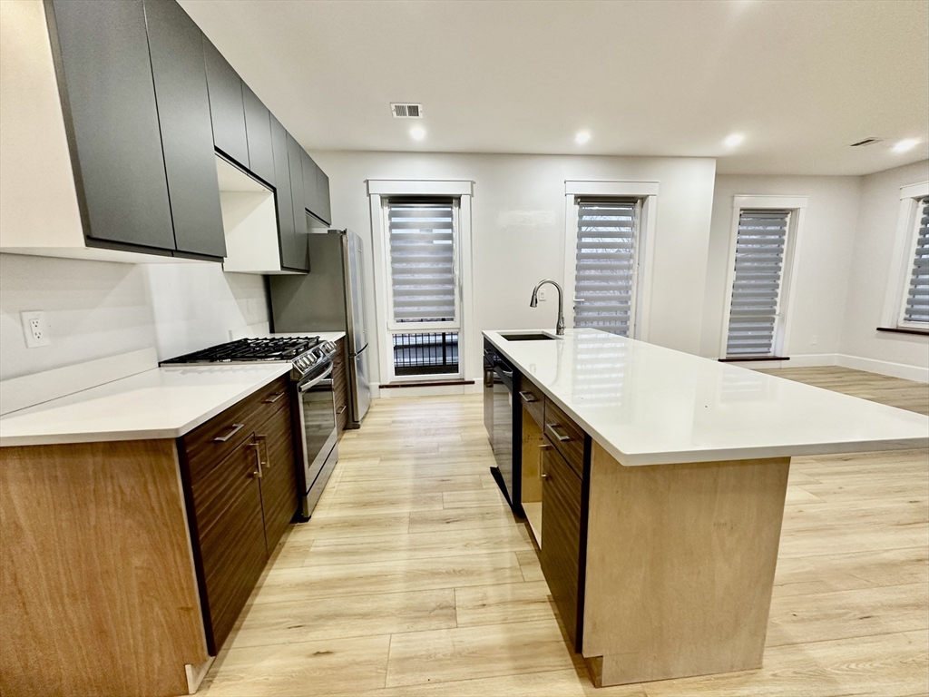 a kitchen with granite countertop a sink a counter top space and cabinets